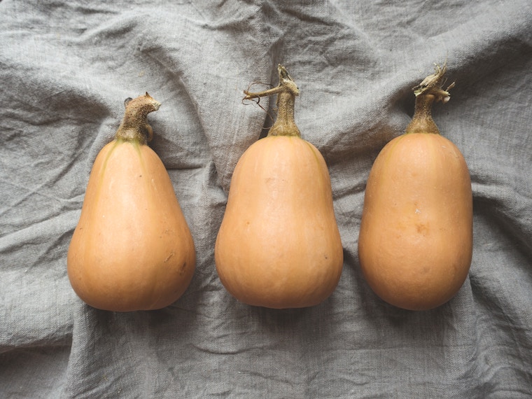 Drei Butternut-Kürbisse auf grauem Leinentuch