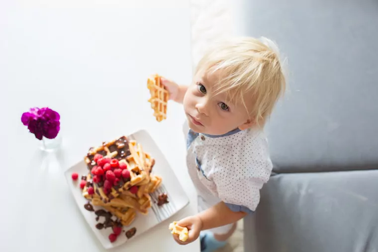 Kleinkind mit einer Waffel in der Hand