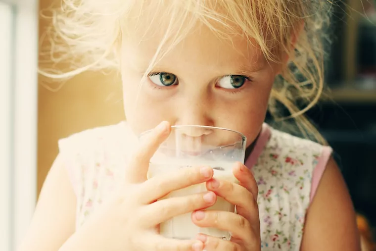 Mädchen mit einem Glas Milch in der Hand