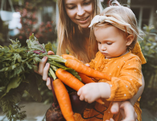 Mutter und Kleinkind betrachten eine Karotte