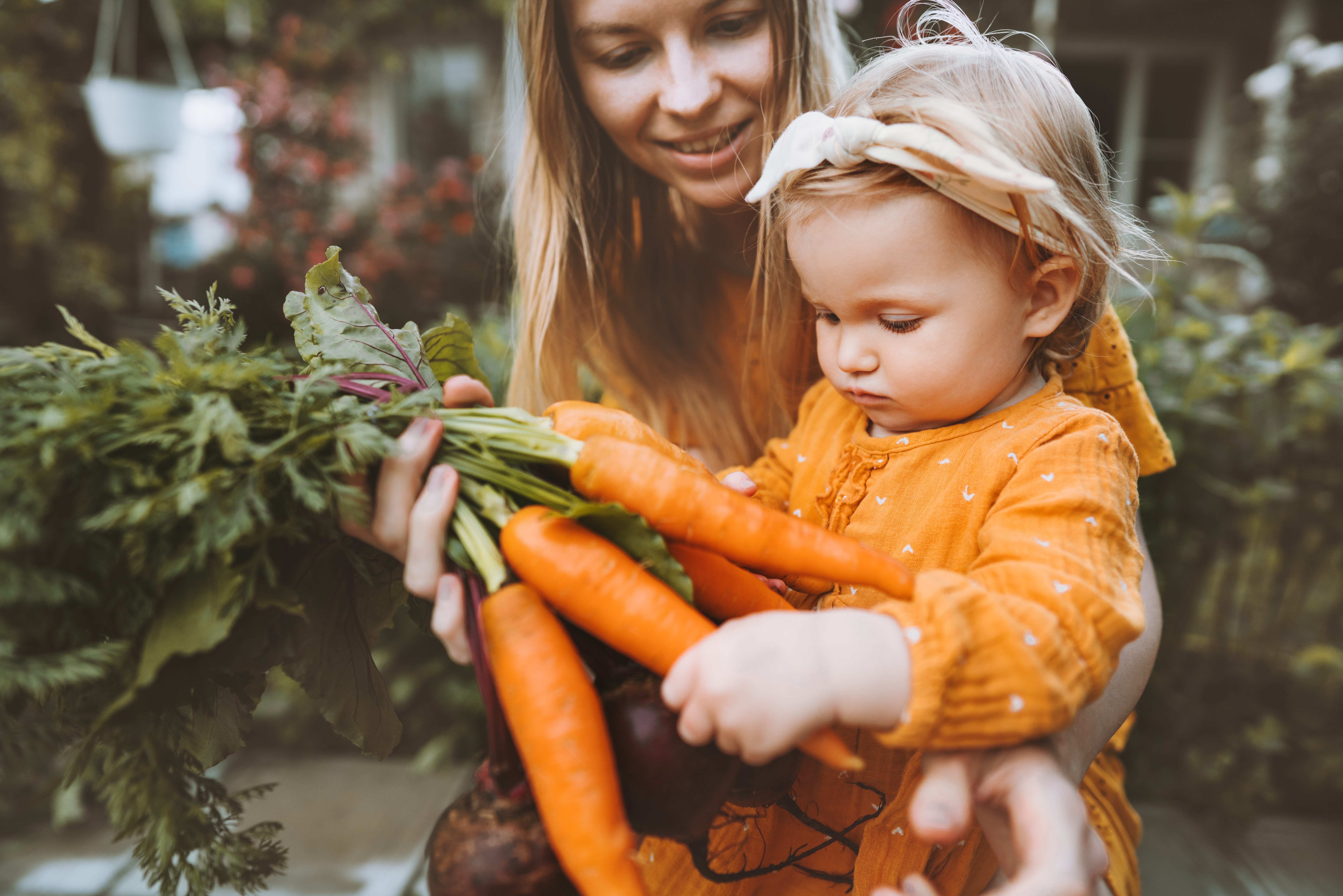 Mutter und Kleinkind betrachten eine Karotte