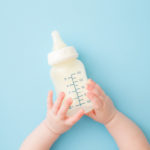 Kleinkind mit Milchflasche in der Hand