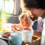 Familie sitzt gemeinsam am Tisch und isst.