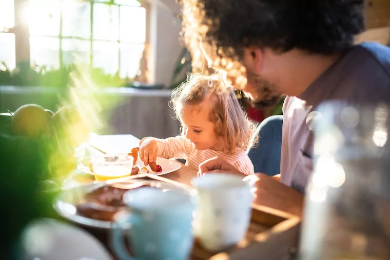 Familie sitzt gemeinsam am Tisch und isst.