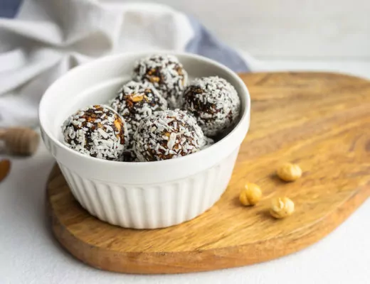 Energy Balls mit Kokosraspeln in einer weißen Schale